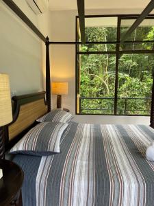 1 dormitorio con cama y ventana grande en Private 5 Bedroom Home with Pool! en Tárcoles