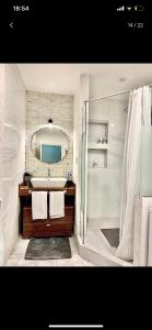 La salle de bains est pourvue d'un lavabo, d'une douche et d'un miroir. dans l'établissement City centre HOTEL STYLE APARTMENT, à Baku