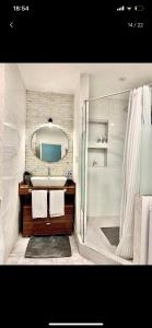 a bathroom with a sink and a shower and a mirror at City centre HOTEL STYLE APARTMENT in Baku