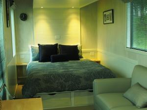 a small bedroom with a bed and a couch at Boutique Tiny House - Te Anau Country Accommodation in Te Anau