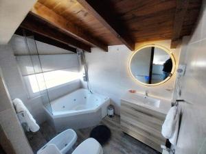 a bathroom with two toilets and a tub and a sink at Las Victorias Suites Bariloche in San Carlos de Bariloche