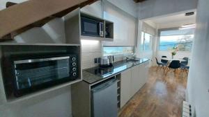 een keuken met een spoelbak en een fornuis bovenste oven bij Las Victorias Suites Bariloche in Bariloche