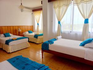 a bedroom with two beds and a window at Hotel Sula Sula in Puerto Villamil