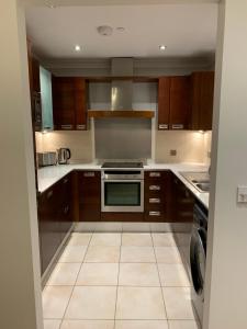 a kitchen with wooden cabinets and a stove top oven at Killarney Town Apartment in Killarney