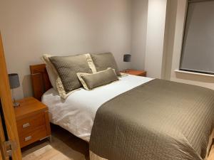 1 dormitorio con 1 cama, 2 mesitas de noche y ventana en Killarney Town Apartment en Killarney