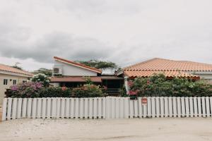 a white picket fence in front of a house at Bubali Studio in Palm-Eagle Beach