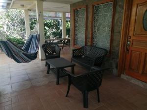 un portico con 2 sedie e un'amaca di Gaia Lodge a Boquete