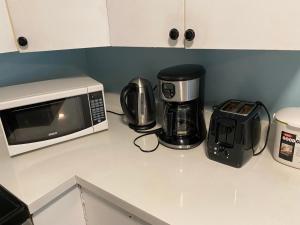 a kitchen counter with a microwave and a coffee maker at jane's cozy suite in Surrey