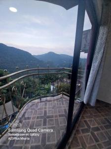 a room with a balcony with a view of the mountains at Hotel El Mirador in Xilitla