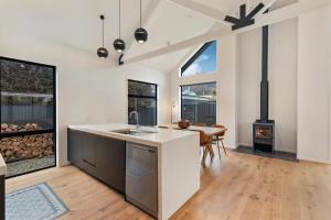 an open kitchen with a stove and a dining room at Luxe Arrowtown Home in Arrowtown