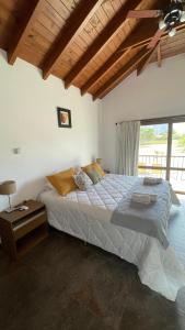 a bedroom with a large bed with a wooden ceiling at Wayra huasi in Cafayate