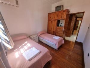 a small bedroom with two beds and a dresser at La Gran Posada in Ciudad Lujan de Cuyo