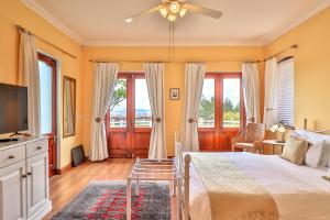 um quarto com uma cama e uma ventoinha de tecto em Apricot Gardens Guesthouse em Gordonʼs Bay