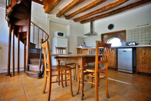 a kitchen with a wooden table and chairs at Domaine de Matounet in Bridoré