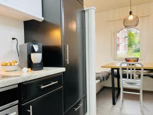 a black refrigerator in a kitchen with a table at -The Urbanist- Lakeview Free Parking 2BD Fast WiFi in Oberhofen am Thunersee