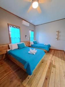 2 Betten in einem Zimmer mit einem Kreuz an der Wand in der Unterkunft The Odyssey Resort Utila in Utila