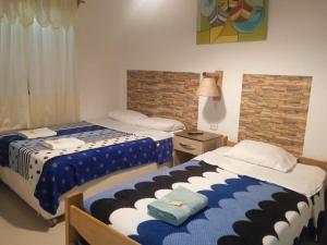 1 dormitorio con 2 camas y ventana en Hostal Brisa Marina, en Paracas