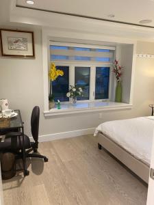 a bedroom with a bed and a window with flowers at Six minutes to Rupert station in Vancouver