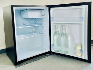 an open refrigerator with two bottles of milk at Charm on Chippendale B&B in Palmerston North