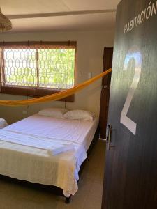 1 dormitorio con 1 cama y un cartel en la puerta en BAMBUU en Ríohacha