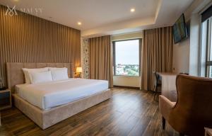 Mai Vy Hotel Tay Ninh في Tây Ninh: غرفة نوم بسرير ومكتب ونافذة
