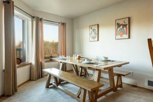 a dining room with a wooden table and a bench at Cozy 2 bedroom condo walking distance from the beach in Ocean Shores