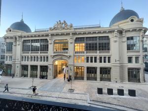 un grand bâtiment avec des personnes qui marchent devant lui dans l'établissement B The Guest Downtown, à Porto