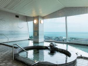 淡路的住宿－KAMENOI HOTEL Awajishima，享有城市景致的建筑内的热水浴池