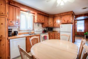 uma cozinha com uma mesa e um frigorífico branco em Maison chaleureuse a 15 minutes DT Montréal em Montreal