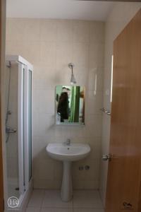een badkamer met een wastafel en een spiegel bij Hotel Roterdão "Under New Management" in Praia