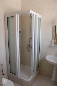 a glass shower in a bathroom with a sink at Hotel Roterdão "Under New Management" in Praia