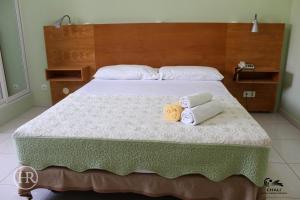 a bedroom with a bed with two towels on it at Hotel Roterdão "Under New Management" in Praia