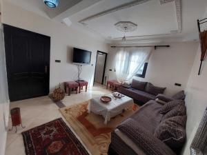 uma sala de estar com um sofá e uma mesa em Samsat House Apartment Taghazout em Taghazout