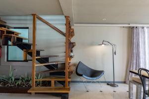 escalera en una habitación con silla y lámpara en Lotus Midtown Apartments by BVR, en Playa del Carmen