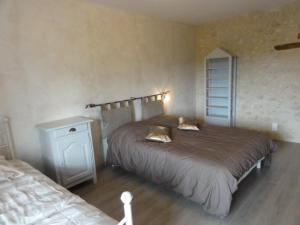 ein Schlafzimmer mit einem großen Bett und einem Nachttisch in der Unterkunft Gîte Charroux - Allier, 4 pièces, 7 personnes - FR-1-489-271 in Charroux-dʼAllier