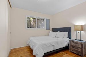een witte slaapkamer met een bed en een raam bij A place to CHILL! in Portland
