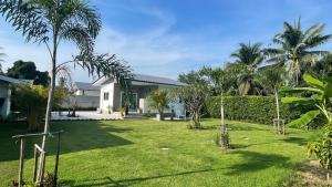 Blick auf den Hof eines Hauses mit Palmen in der Unterkunft Happy House in Cha-am