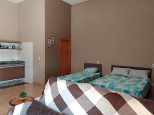 a room with two beds and a kitchen in it at Flatinho LINDO em Olímpia a 4km do Thermas dos laranjais in Olímpia
