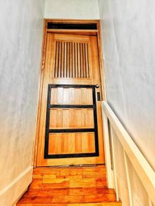 pasillo con puerta de madera en un edificio en Omotenashi House of Santa Rosa City Laguna, en Caingin