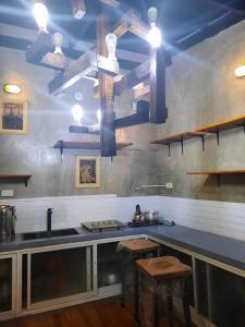 cocina con fregadero y encimera con taburetes en Omotenashi House of Santa Rosa City Laguna, en Caingin