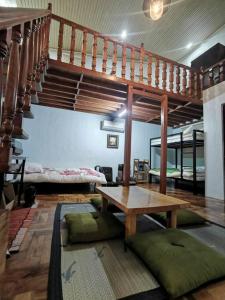 a living room with a wooden table and stairs at Omotenashi House of Santa Rosa City Laguna in Caingin