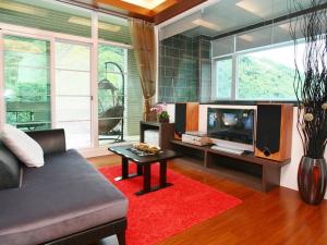 a living room with a couch and a tv at Shan Quan Zhi Lian Homestay in Datong