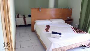 a bedroom with a large bed with a wooden headboard at Hotel Roterdão "Under New Management" in Praia