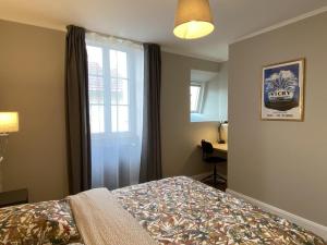 a bedroom with a bed and a window and a desk at Appartement Vichy, 2 pièces, 2 personnes - FR-1-489-364 in Vichy