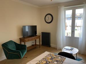 a living room with a tv and a chair and a table at Appartement Vichy, 2 pièces, 2 personnes - FR-1-489-364 in Vichy