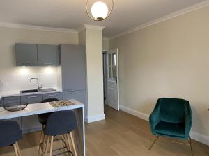 eine Küche mit einer Theke und einem grünen Stuhl in der Unterkunft Appartement cosy au cœur de Vichy, proche thermes et commerces, tout inclus, idéal 2 pers. + options - FR-1-489-364 in Vichy