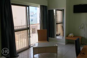 a living room with a view of a balcony at Hotel Roterdão "Under New Management" in Praia