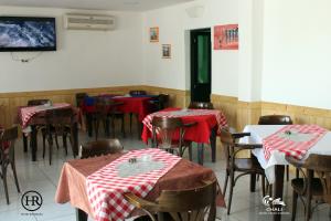 a dining room with red and white tables and chairs at Hotel Roterdão "Under New Management" in Praia