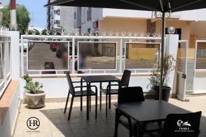 een patio met tafels, stoelen en ramen bij Hotel Roterdão "Under New Management" in Praia
