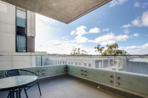 a balcony with a table and chairs and a view at Accommodate Canberra - Realm Residences in Canberra